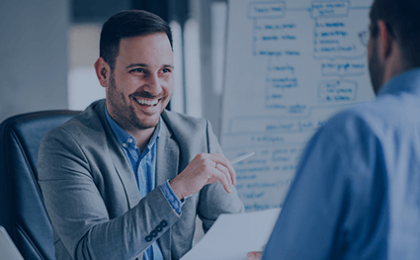 man next to whiteboard smiling